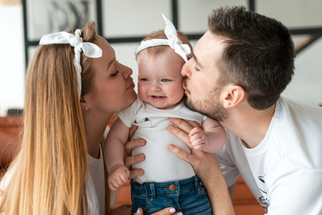 Baby being kissed by parents after picking up the baby from day care